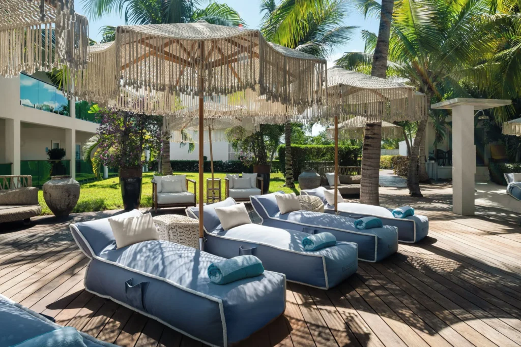 Blue cushioned loungers under fringed umbrellas at The Oasis at Grace Bay.